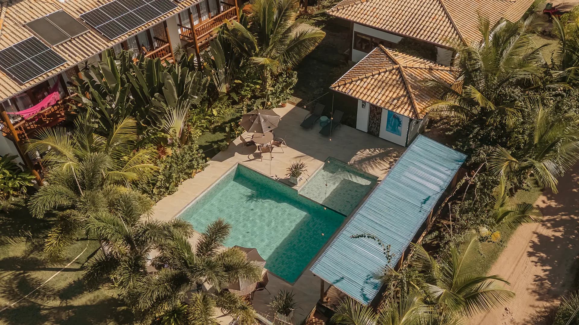 Aerial view of Taipu Bay surrounded by tropical vegetation, with a swimming pool at the center.